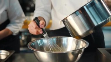 Milk is churned in a professional restaurant kitchen. Dessert cooking.