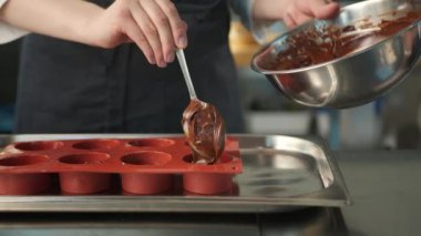 Close-up of chocolate being placed in baking dish. Brownie preparation.