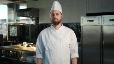 Professional kitchen, portrait: Male Chef folds his arms and looks at camera