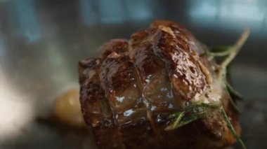 Close-up: Chef pouring sauce over a filet mignon while cooking