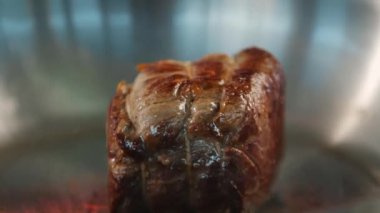 Close-up of a filet mignon being cooked in frying pan