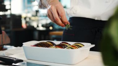 Close-up: The chef adds spices to ratatouille. The process of preparing food in restaurant.
