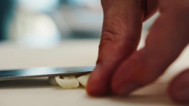 Close-up: Chef chopping an onion with fine pressure on a cutting surface in professional kitchen