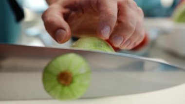 Close-up: The chef cuts the zucchini finely with knife