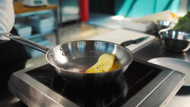 Professional restaurant kitchen, close-up: the process of cooking an omelette in frying pan