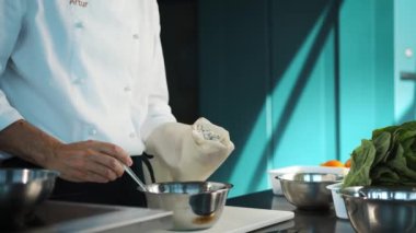 Professional restaurant kitchen, close-up: The chef puts sauce in the confectionery sleeve