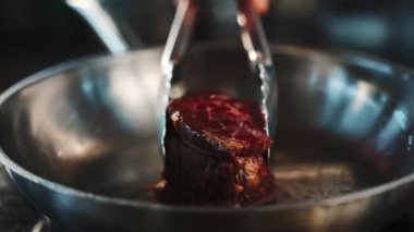 Close-up of a raw filet mignon being cooked in frying pan