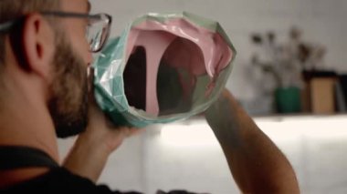A male creator, sculptor, handyman creates handmade art object.