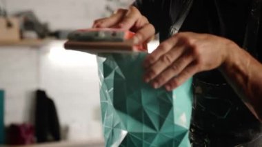 A male craftsman creates decorative product with his own hands. Handmade, workshop. Creative chaos.