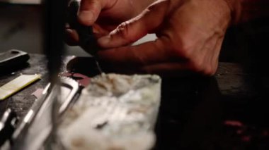 Close-up of artisan craftsman mixing paint in a workshop.