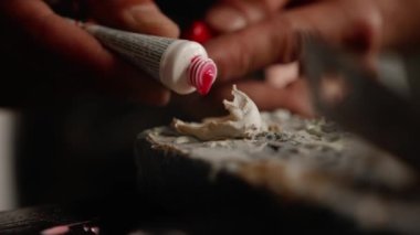 Close-up of artisan craftsman mixing paint in a workshop.