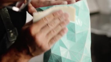 Close-up: a male artisan painter sculptor wipes the product, puts things in order in workshop