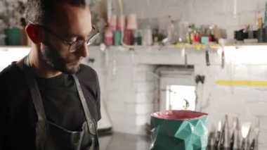 Male craftsman burns his product with gas burner in the workshop