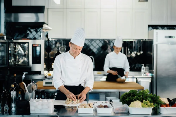 Professional kitchen: two chefs prepare delicious dish in a restaurant