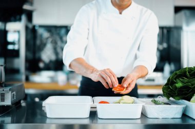 Professional kitchen of the restaurant, close-up: chef collects ratatouille from vegetables