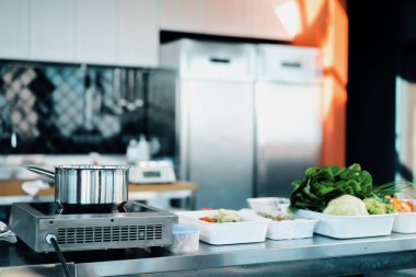Wide angle: professional cuisine in restaurant. Stove, saucepan, vegetables
