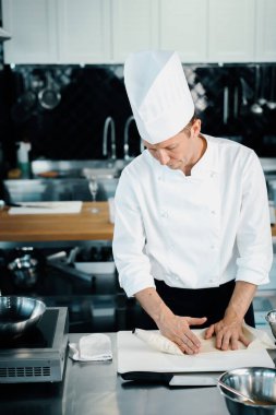 Professional kitchen of a restaurant, close-up: a male chef prepares a filling for french omelet
