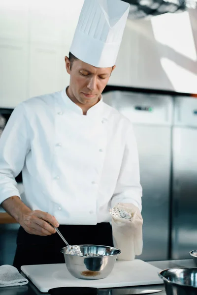 Professional kitchen of a restaurant, close-up: a male chef prepares a filling for french omelet
