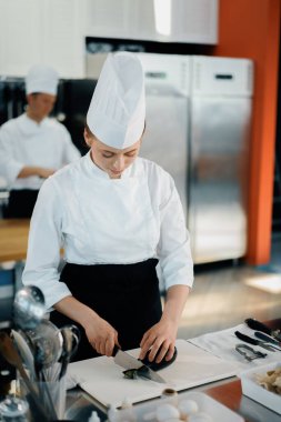 Professional kitchen, the chef cuts the eggplant finely on the cutting surface in restaurant