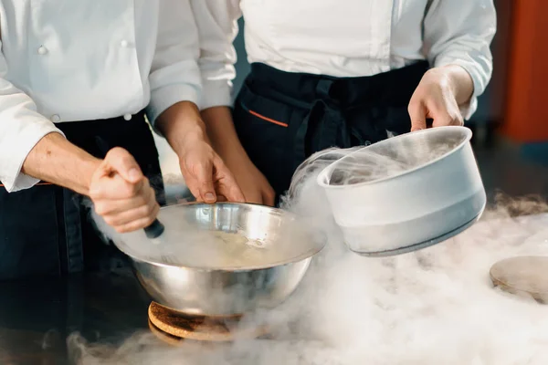 Professional kitchen, chefs use liquid nitrogen to cook molecular food in restaurant