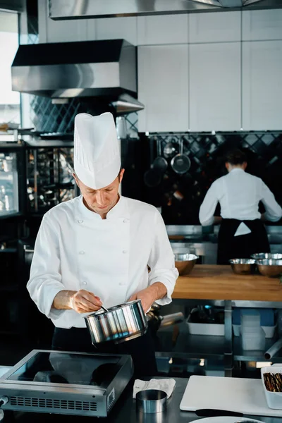 Professional kitchen: two chefs prepare delicious dish in a restaurant