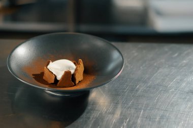 Close-up: ready-made brownie with ice cream in professional kitchen restaurant