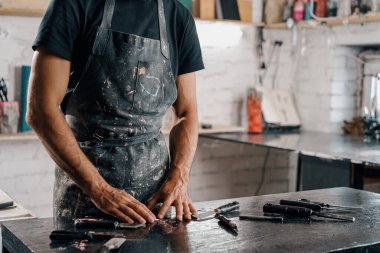 Close-up: tired hands of men painter sculptor artisan in art workshop