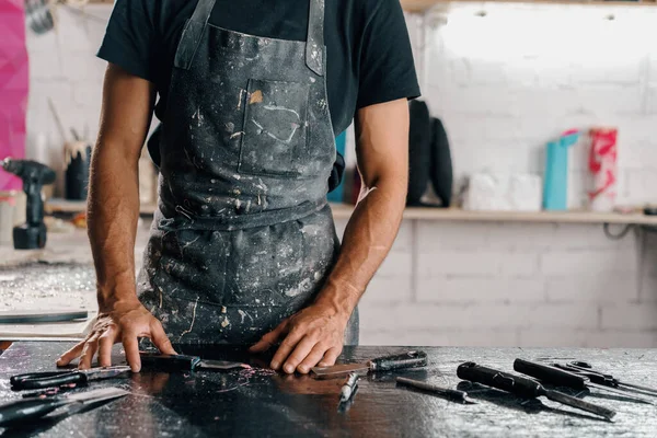 Close-up: tired hands of men painter sculptor artisan in art workshop