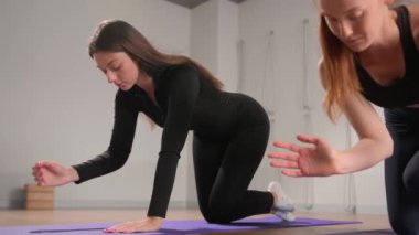 Woman learn yoga pilates with coach trainer. Girl using mat exercise, follow fitness instructor workout for health