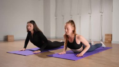 Woman learn yoga pilates with coach trainer. Girl using mat exercise, follow fitness instructor workout for health