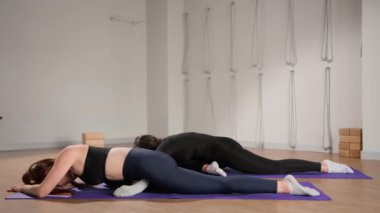 Woman learn yoga pilates with coach trainer. Girl using mat exercise, follow fitness instructor workout for health