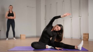 Woman learn yoga pilates with coach trainer. Girl using mat exercise, follow fitness instructor workout for health