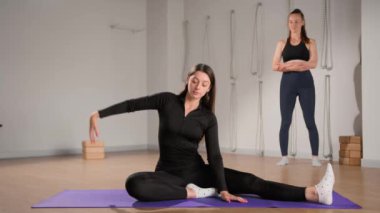 Woman learn yoga pilates with coach trainer. Girl using mat exercise, follow fitness instructor workout for health