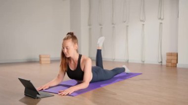 Fitness coach teaching yoga online to group of people. People practicing yoga with trainer with video conference.