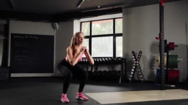 Girl athlete doing squats in gym