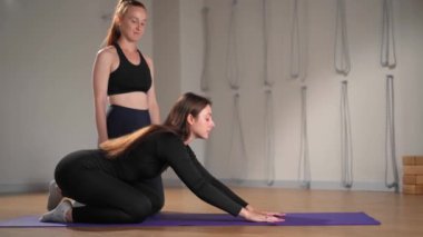 Woman learn yoga pilates with coach trainer. Girl using mat exercise, follow fitness instructor workout for health