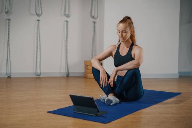 Athletic woman doing yoga pilates stretching online workout in studio or at home