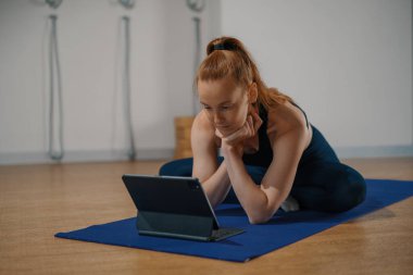 Athletic woman doing yoga pilates stretching online workout in studio or at home