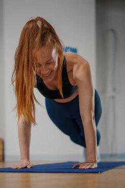Athletic woman doing pilates yoga stretching for health in the studio. Athletic body girl.