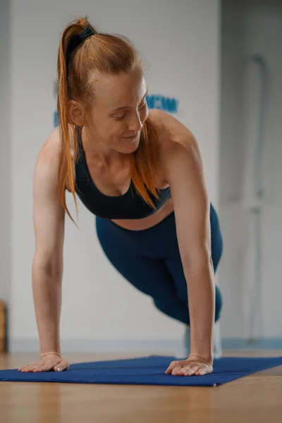 Athletic woman doing pilates yoga stretching for health in the studio. Athletic body girl.