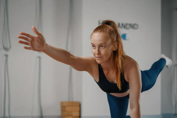 Athletic woman doing pilates yoga stretching for health in the studio. Athletic body girl.