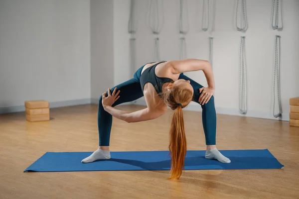 Athletic woman doing pilates yoga stretching for health in the studio. Athletic body girl.