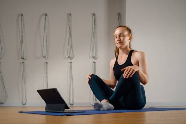 Athletic woman doing yoga pilates stretching online workout in studio or at home