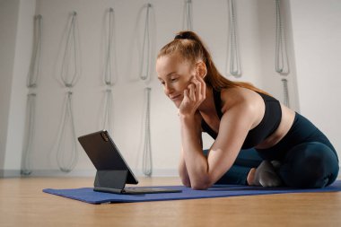 Athletic woman doing yoga pilates stretching online workout in studio or at home