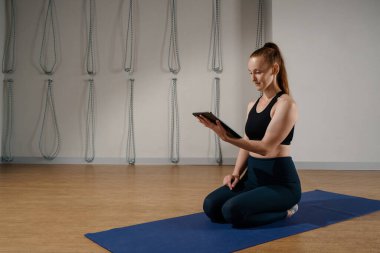 Athletic woman doing yoga pilates stretching online workout in studio or at home