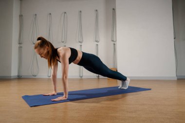 Athletic woman doing pilates yoga stretching for health in the studio. Athletic body girl.