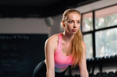 Athletic woman is engaged in training push-ups in gym. chest and arm exercises