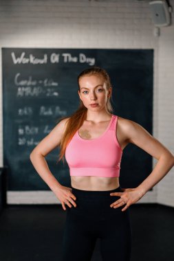 Athletic woman posing and showing her shape in t gym