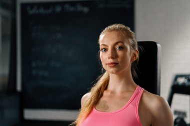 Athletic woman posing and showing her shape in t gym