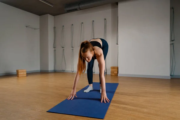 Athletic woman doing pilates yoga stretching for health in the studio. Athletic body girl.